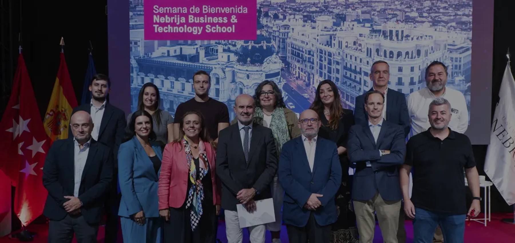 Un grupo de personas posando en un evento relacionado con la Semana de Bienvenida en una escuela de negocios y tecnología.