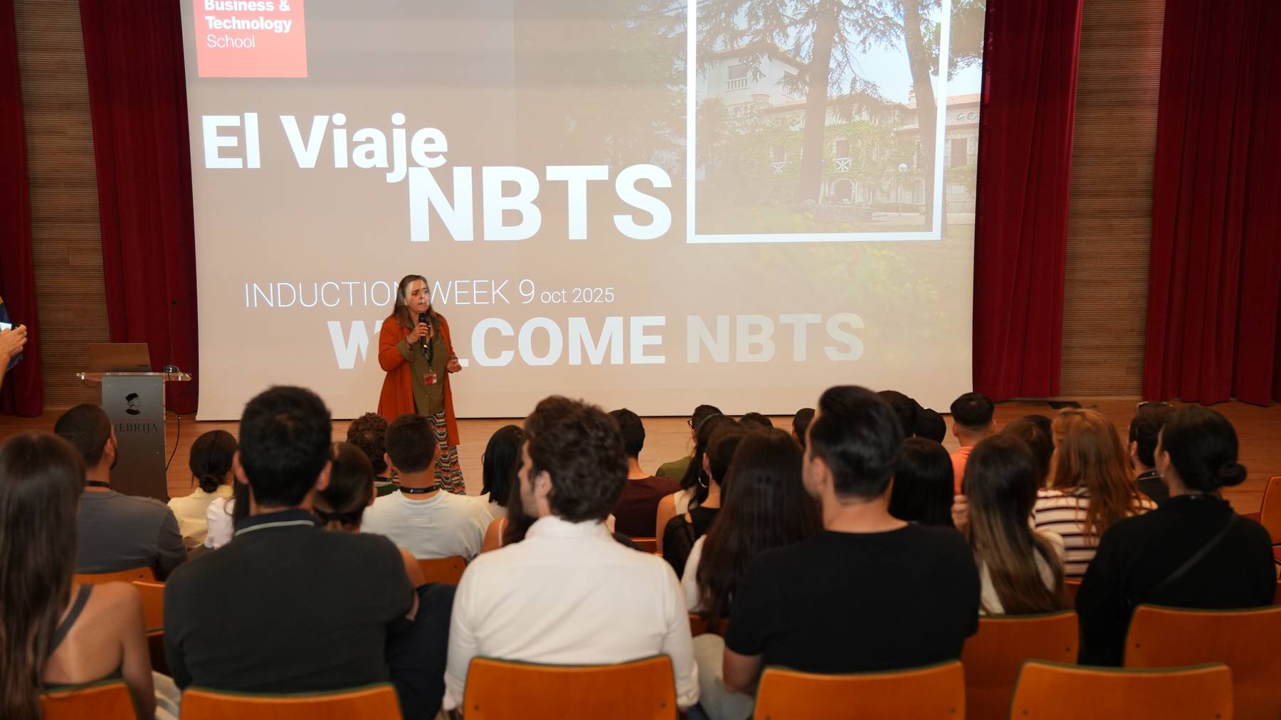 Una presentación en un evento de bienvenida para nuevos estudiantes en una escuela de negocios.