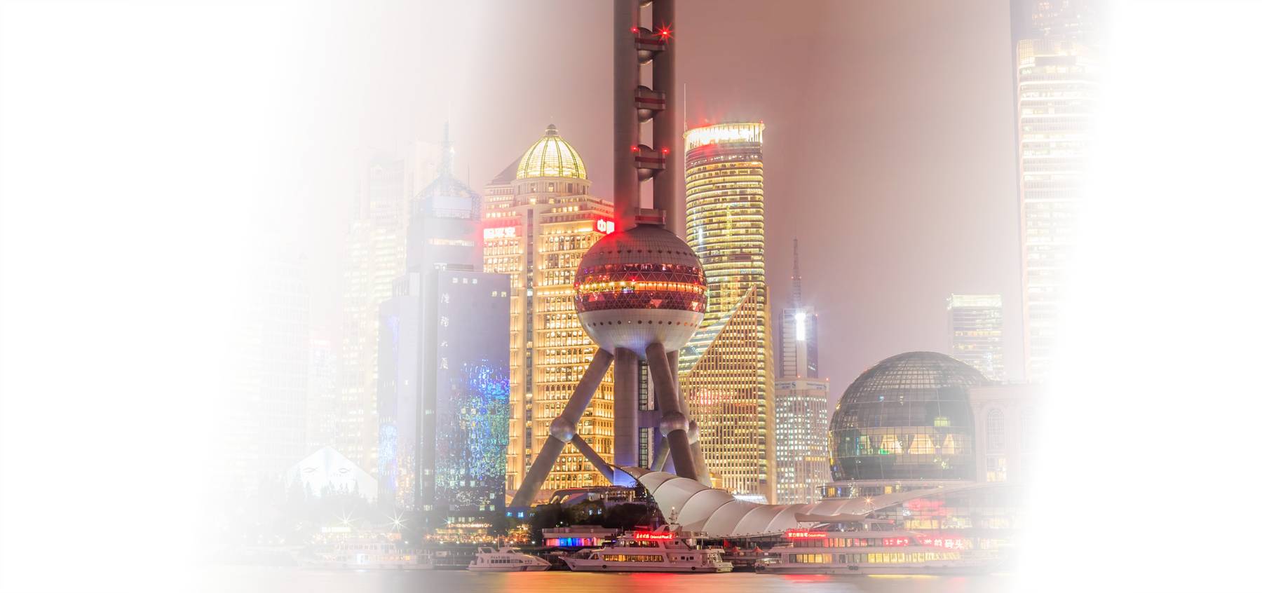 Una vista nocturna del horizonte de Shanghái iluminado por luces de colores brillantes.