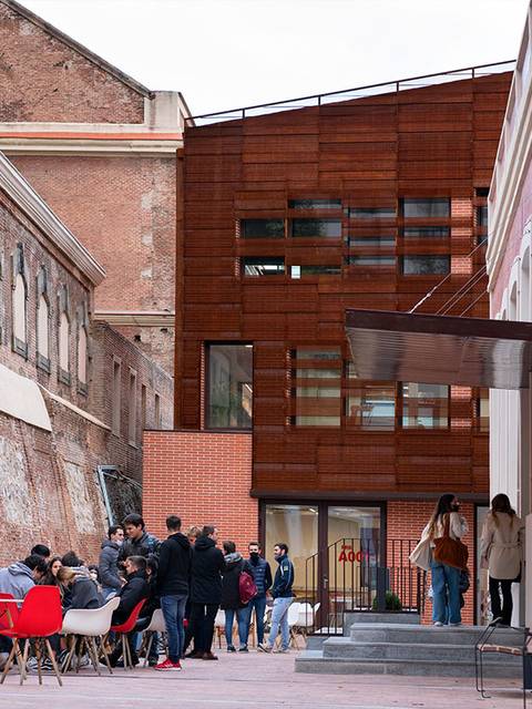 Un grupo de personas se reúne en una terraza en un entorno urbano moderno.