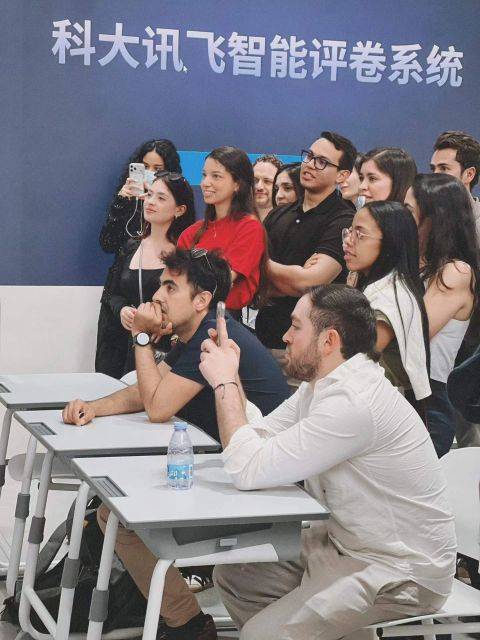 Un grupo de personas observa atentamente una presentación en un evento.