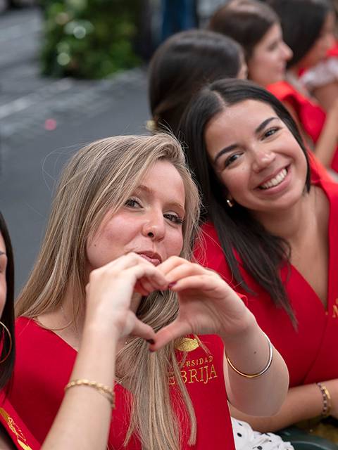 Grupo de graduadas mostrando su felicidad con un gesto de corazón.