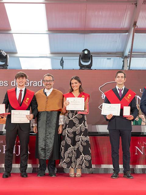 Una ceremonia de graduación en la Universidad Nebrija con varios graduados y un orador en el centro.