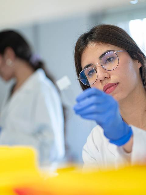 Una joven científica está analizando una muestra en un laboratorio.