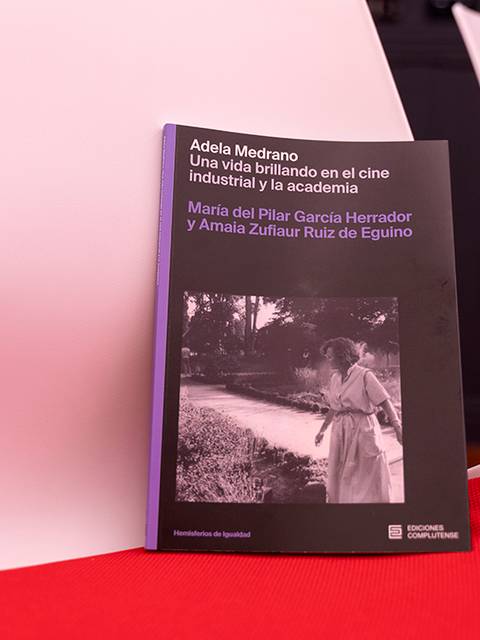 El libro 'Adela Medrano: Una vida brillando en el cine industrial y la academia' se presenta sobre una mesa con sillas de fondo.