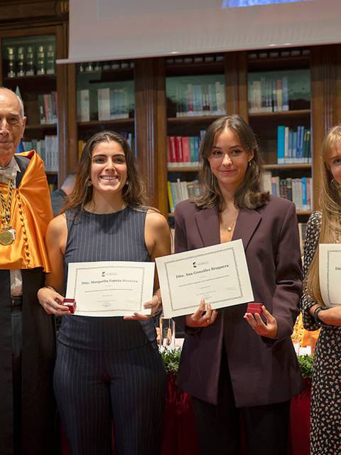 La imagen muestra a un grupo de graduados recibiendo sus certificados en un evento académico formal.