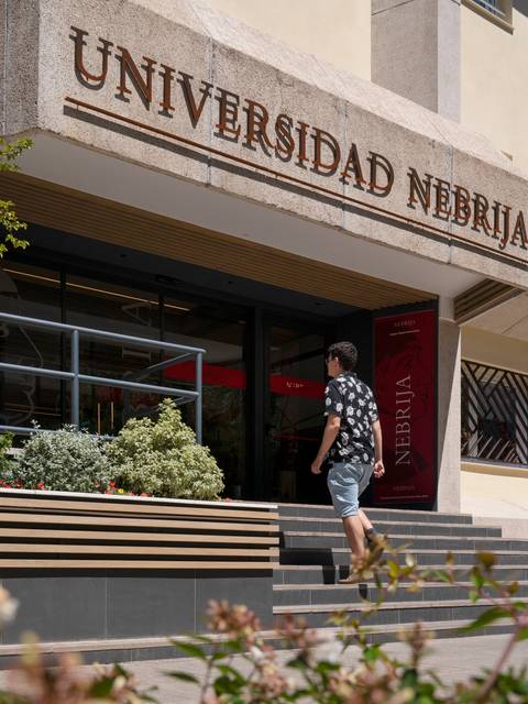 Una persona camina hacia la entrada de la Universidad Nebrija.