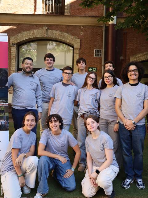 Grupo de personas reunidas frente a un cartel del Club de Divulgación e Investigación Científica.