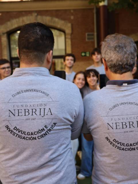 Un grupo de personas está posando al aire libre con camisetas que tienen el logo de la Fundación Nebrija.