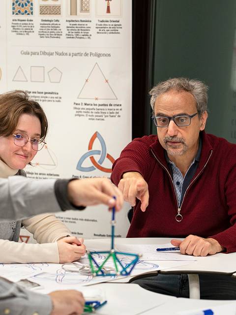 Un grupo de personas discutiendo y trabajando en un proyecto educativo de geometría.