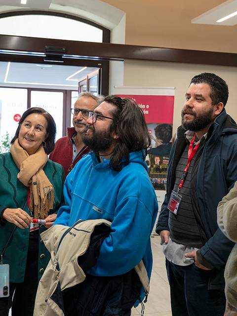 Un grupo de personas observa un mapa en un evento mientras interactúan entre sí.