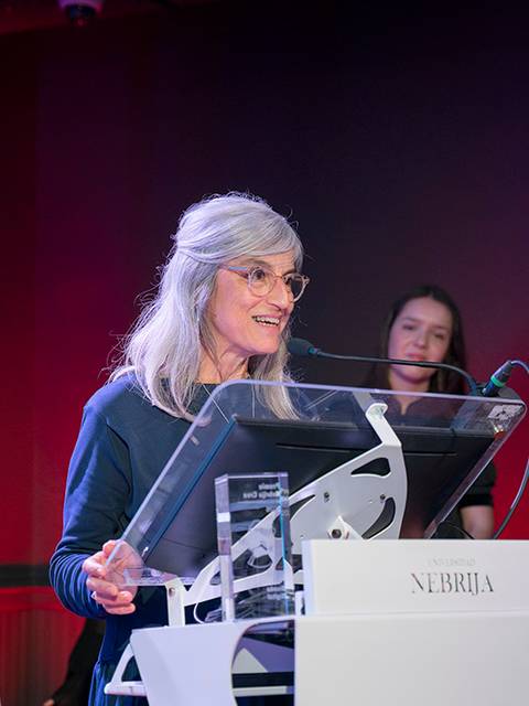 Una mujer con cabello gris presenta en un evento en la Universidad Nebria.