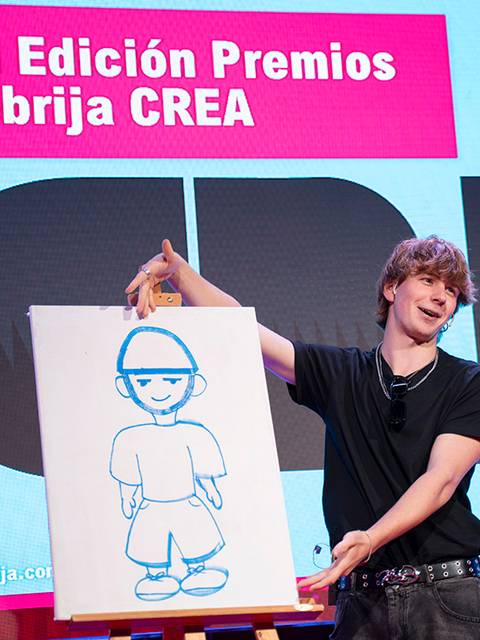 Un joven presenta una ilustración en un evento llamado VII Edición Premios Nebrija CREA.