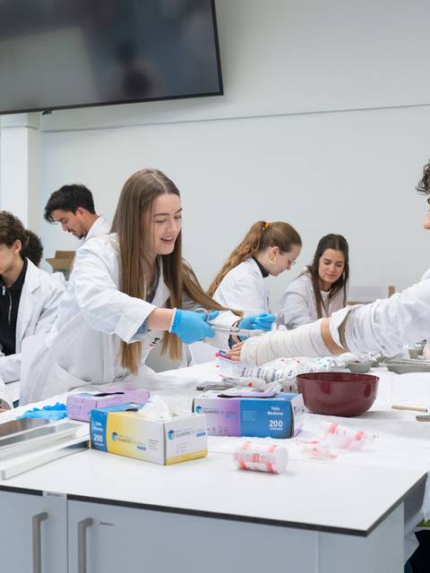 Un grupo de estudiantes en laboratorio realizan prácticas con varios materiales y equipos.