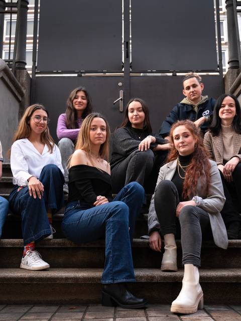 Un grupo de diez personas posando en una escalera al aire libre.