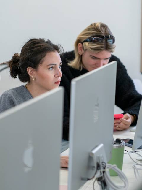 Un grupo de personas trabajando en computadoras en un espacio de estudio.