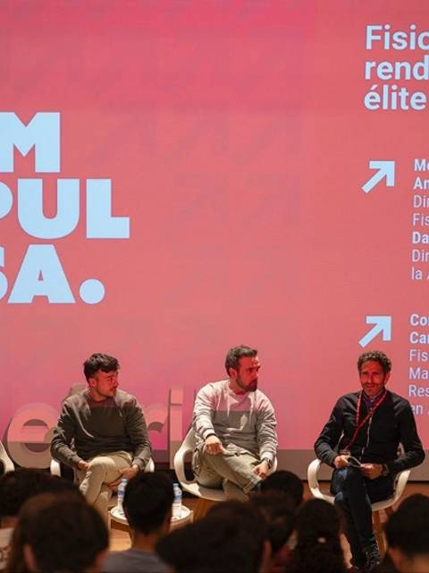 Un panel de discusión sobre fisioterapia y rendimiento en el fútbol, con varios expertos en el tema sentados frente a una audiencia.