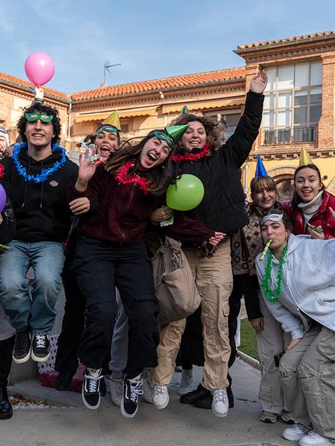 Un grupo de jóvenes celebra y se divierte en una fiesta al aire libre, rodeados de decoraciones navideñas.