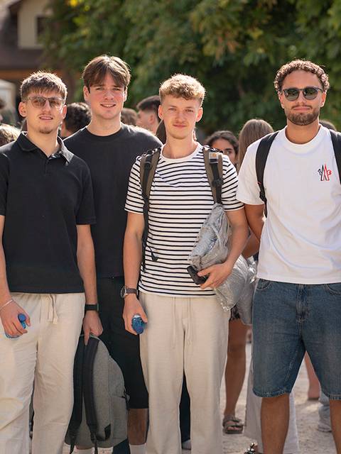 Un grupo de seis jóvenes posando juntos al aire libre con sonrisas en un día soleado.