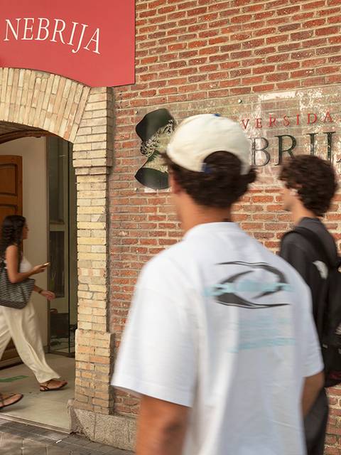 Estudiantes caminando frente a la entrada de la Universidad Nebrija en Madrid.
