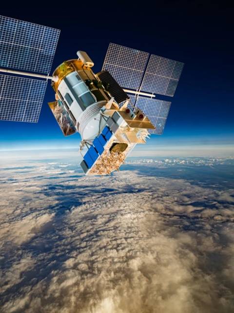 Un satélite en órbita sobre las nubes de la Tierra.
