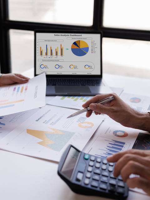 Una reunión de trabajo donde se analizan datos a través de gráficos y una computadora portátil.