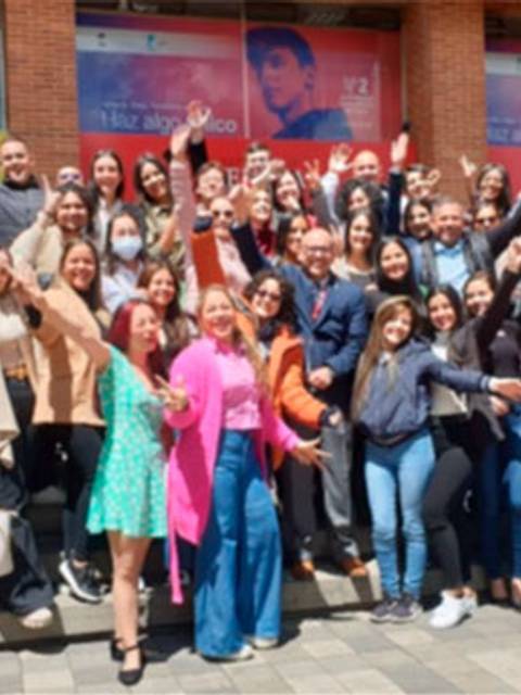 Un grupo de personas sonrientes y felices posando al aire libre.