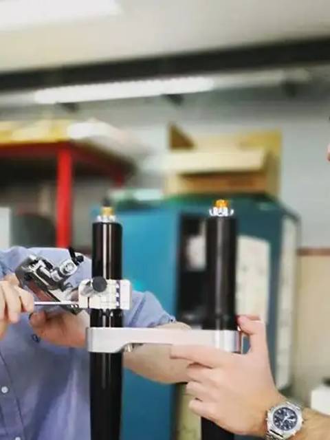 Dos hombres trabajan juntos en un proyecto técnico utilizando herramientas en un entorno de taller.