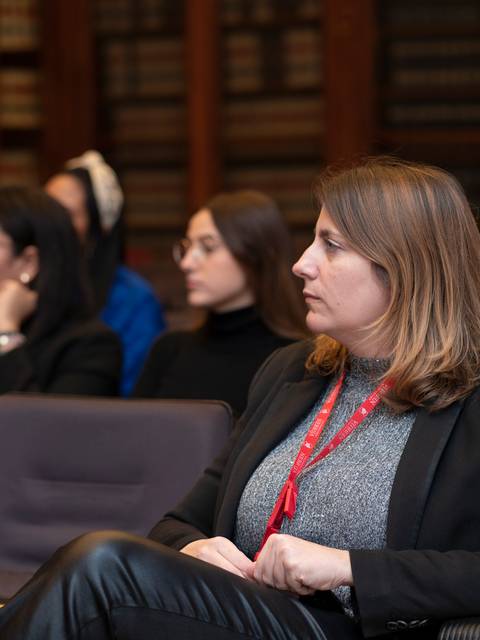 Un grupo de personas escucha atentamente durante una charla en un ambiente académico.