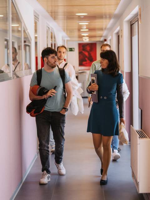 Un grupo de personas camina por un pasillo de un edificio moderno.
