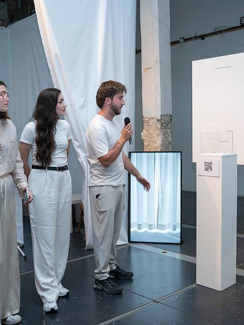 Cuatro personas participan en una presentación en un espacio de arte contemporáneo.
