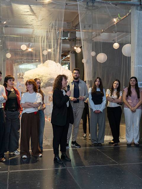 Un grupo de personas asiste a la presentación de proyectos finales en un espacio artístico.