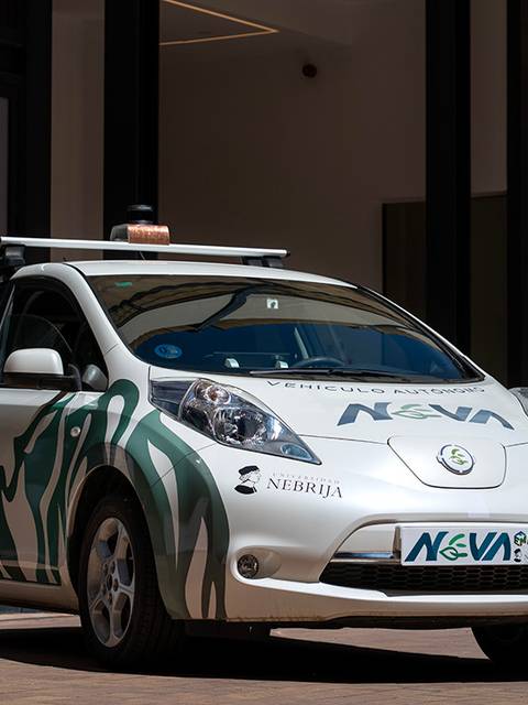 Un automóvil eléctrico decorado con gráficos y slogans en un entorno urbano.