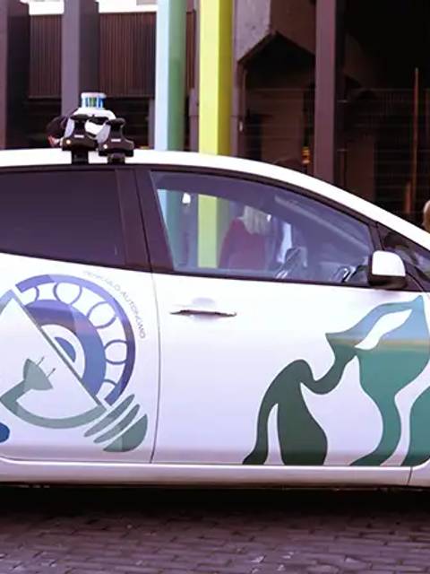 Un coche decorado con un diseño artístico se encuentra estacionado en una calle concurrida.