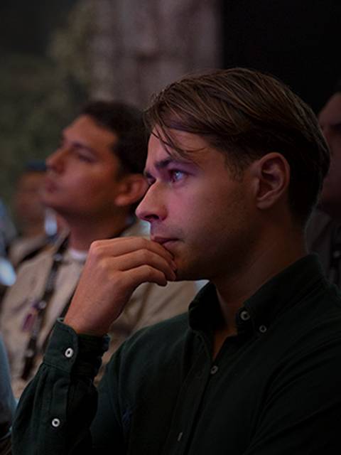 Un grupo de personas escucha atentamente mientras uno de ellos parece pensativo.