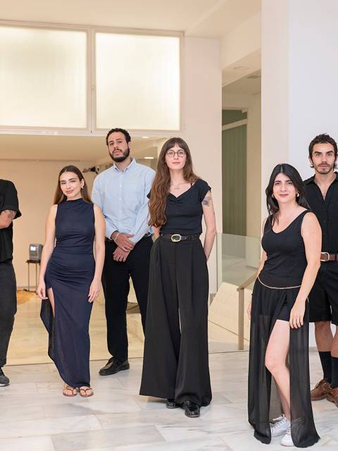 Un grupo de ocho personas posando en un espacio moderno y luminoso.