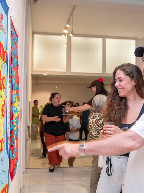 Una pareja observa atentamente una exposición de arte contemporáneo en una galería.