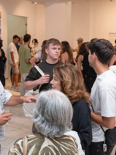 Un grupo de personas conversando en una galería de arte.