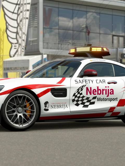 Un coche de seguridad Mercedes-Benz AMG GT con decoraciones de la Universidad Nebrija en un circuito de carreras.