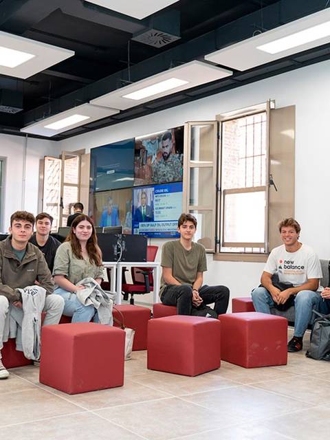 Un grupo de estudiantes posando en un laboratorio de medios con un ambiente moderno.