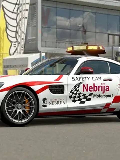 Un coche de seguridad Mercedes con decoraciones de Nebrija Motorsport en un circuito de carreras.