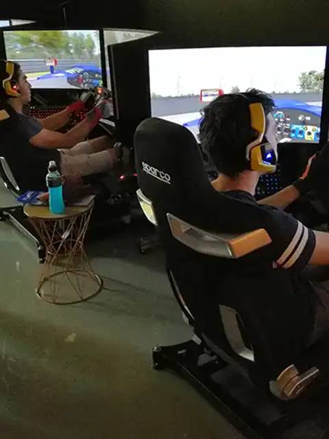 Varias personas disfrutando de una experiencia de simulación de carreras en un entorno virtual.