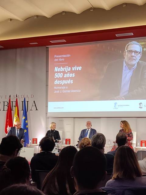 Un evento con un panel de speakers discutiendo sobre la historia de Nebrija en un auditorio.