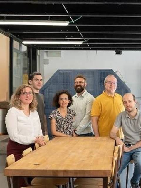 Un grupo de personas posa juntas en un entorno de trabajo moderno.