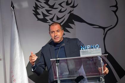 Un hombre vestido de traje habla desde un atril durante un evento.