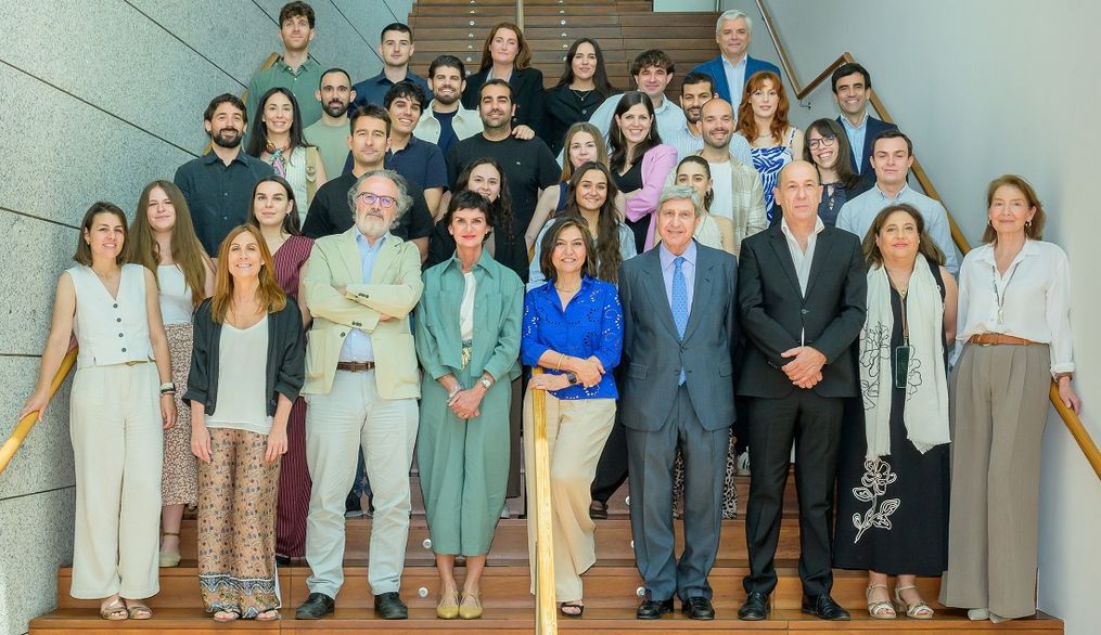 Grupo de personas posando en una escalera interior.