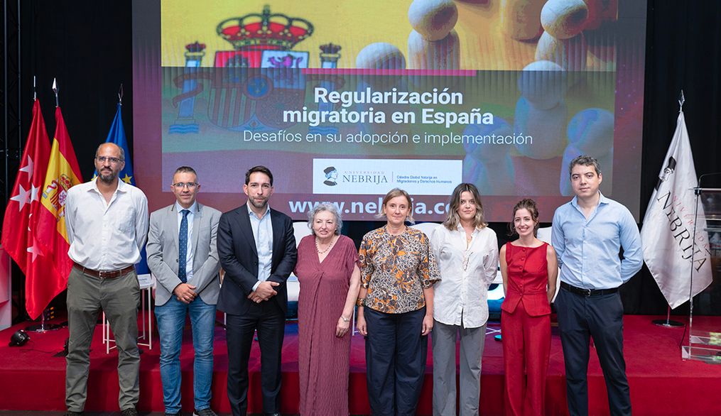 Un grupo de personas posa en un evento relacionado con la regularización migratoria en España.