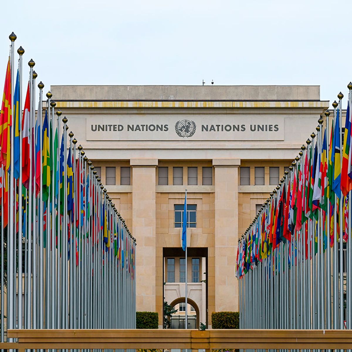 Edificio de las Naciones Unidas en Ginebra, flanqueado por banderas de diferentes países