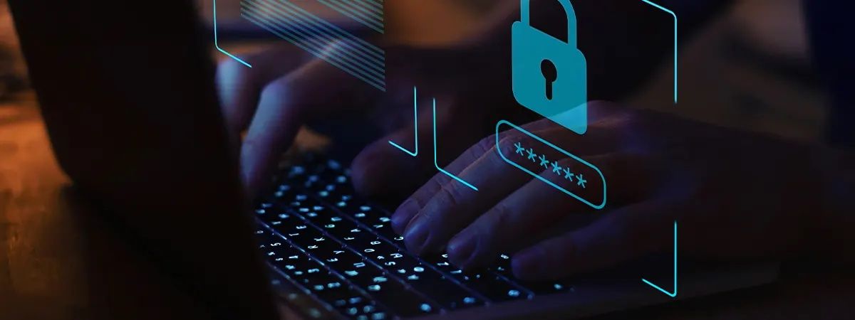 Una persona está escribiendo en un teclado con un gráfico de seguridad digital en la pantalla.