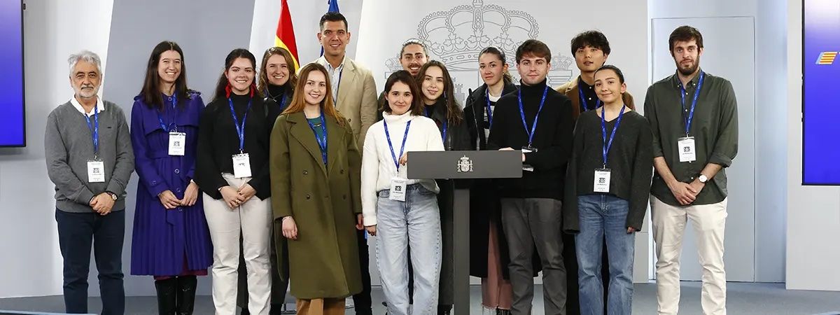 Un grupo de personas posando junto a un podio en un evento oficial.